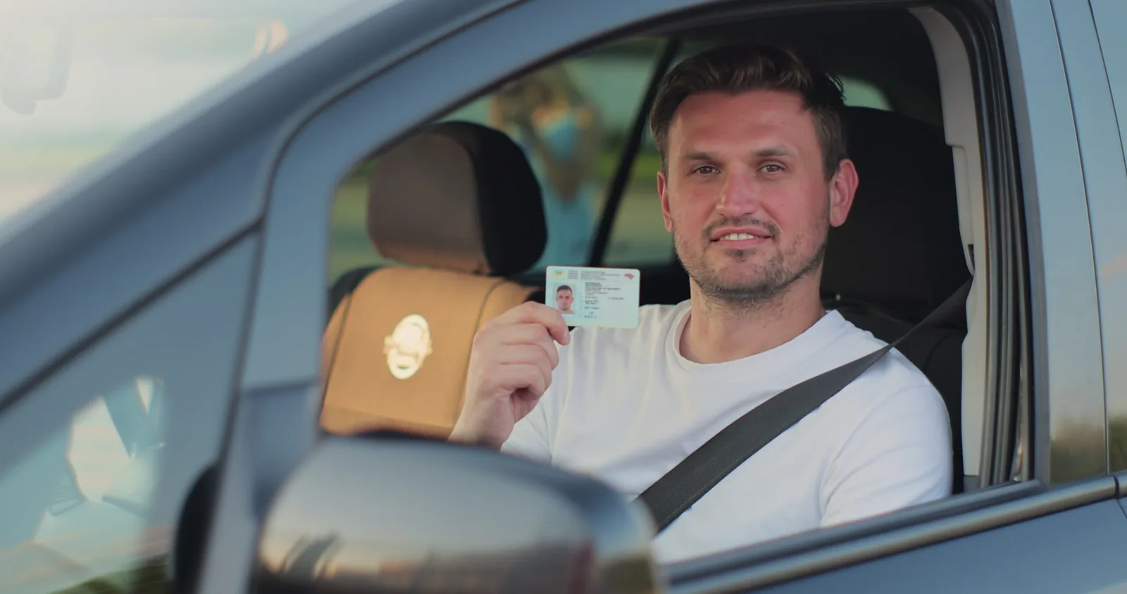 Conducteur souriant tenant un permis de conduire numérique